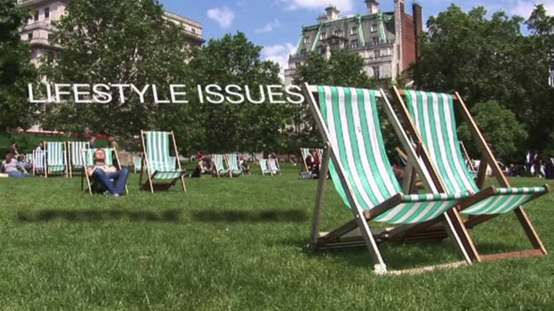 Two empty deckchairs in a park.